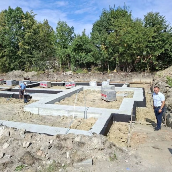 Plac budowy budynku wielorodzinnego przy ul. Robotniczej w Łomazach, widoczne wykonane fundamenty i materiały budowlane